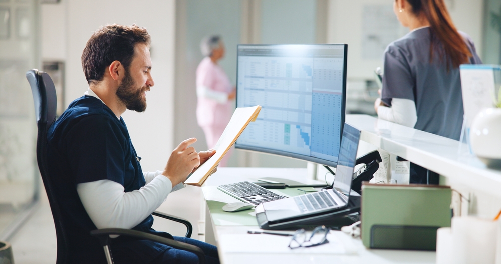 nurse sitting at desk with files